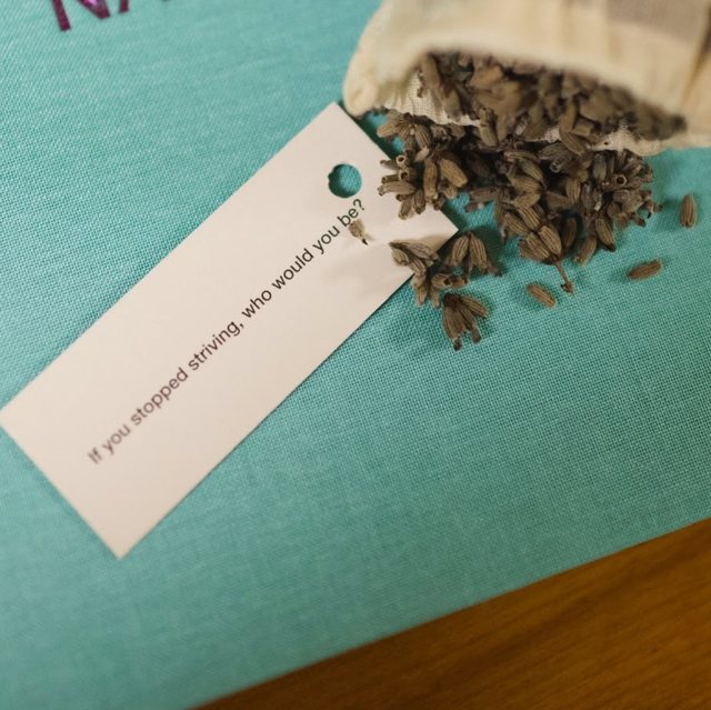 A pouch of dried lavender and a question card on a hand-bound notebook