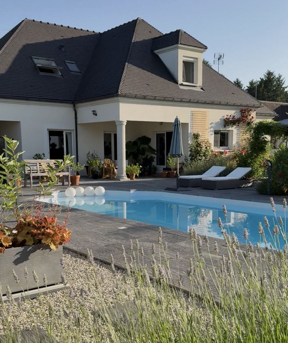 Lavender House: a white house with a slate roof, a pool and lavender in front