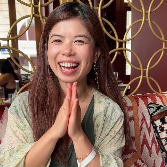 Joei laughing with her hands pressed together