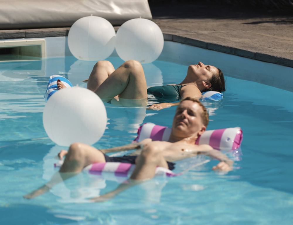 Two people floating on their backs in the pool at Lavender House