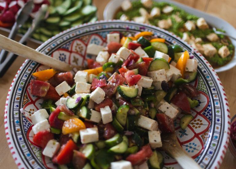 A big painted bowl of tomato, cucumber and feta salad