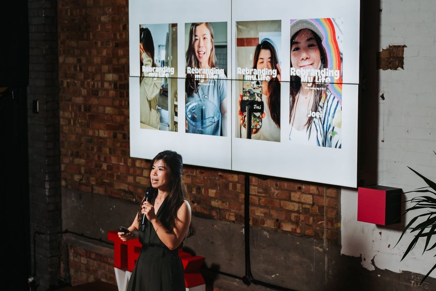 Joei Chan speaking at TEDx with slides from her talk behind her